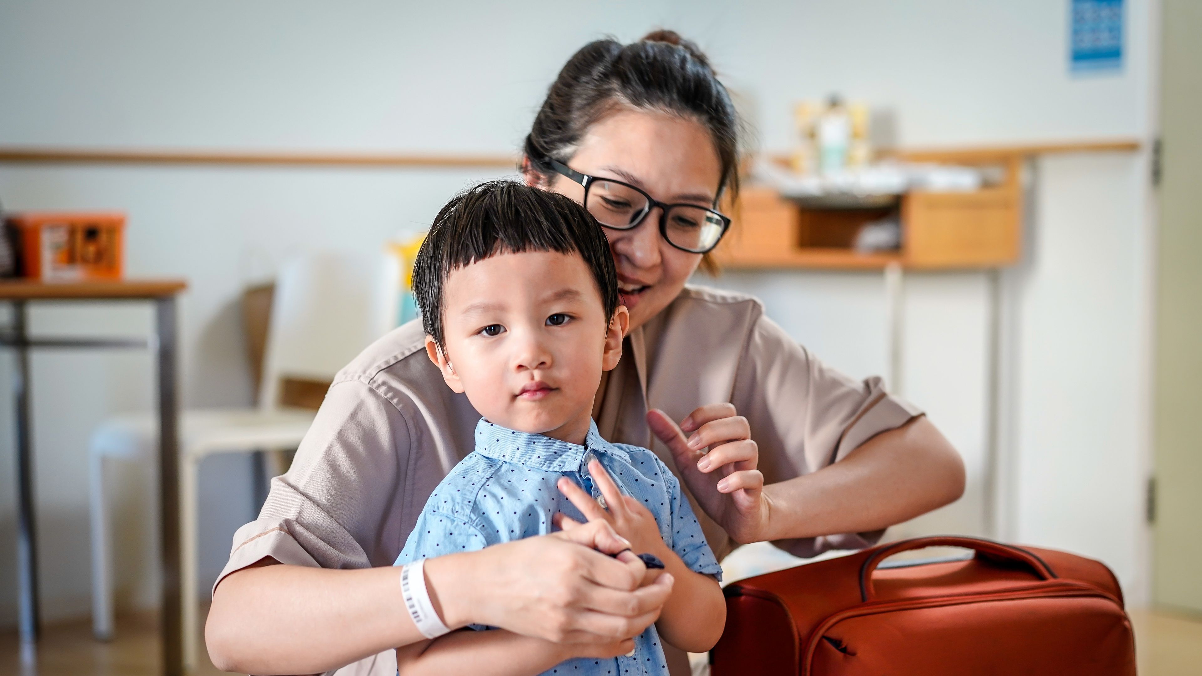 Seorang ibu dan anak lelakinya bersiap sedia untuk perjalanan. 