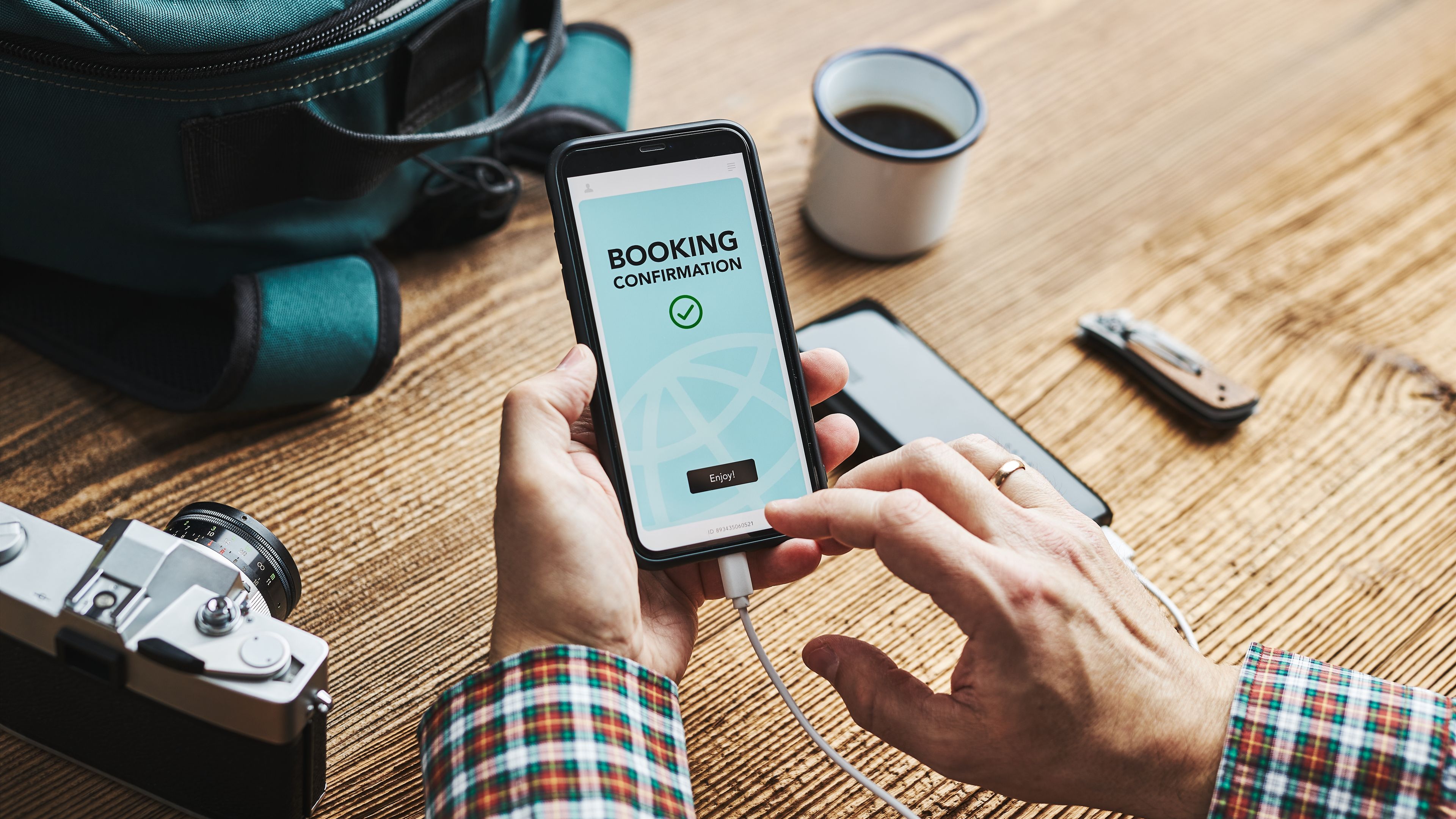 A traveler is using his smartphone to confirm a booking