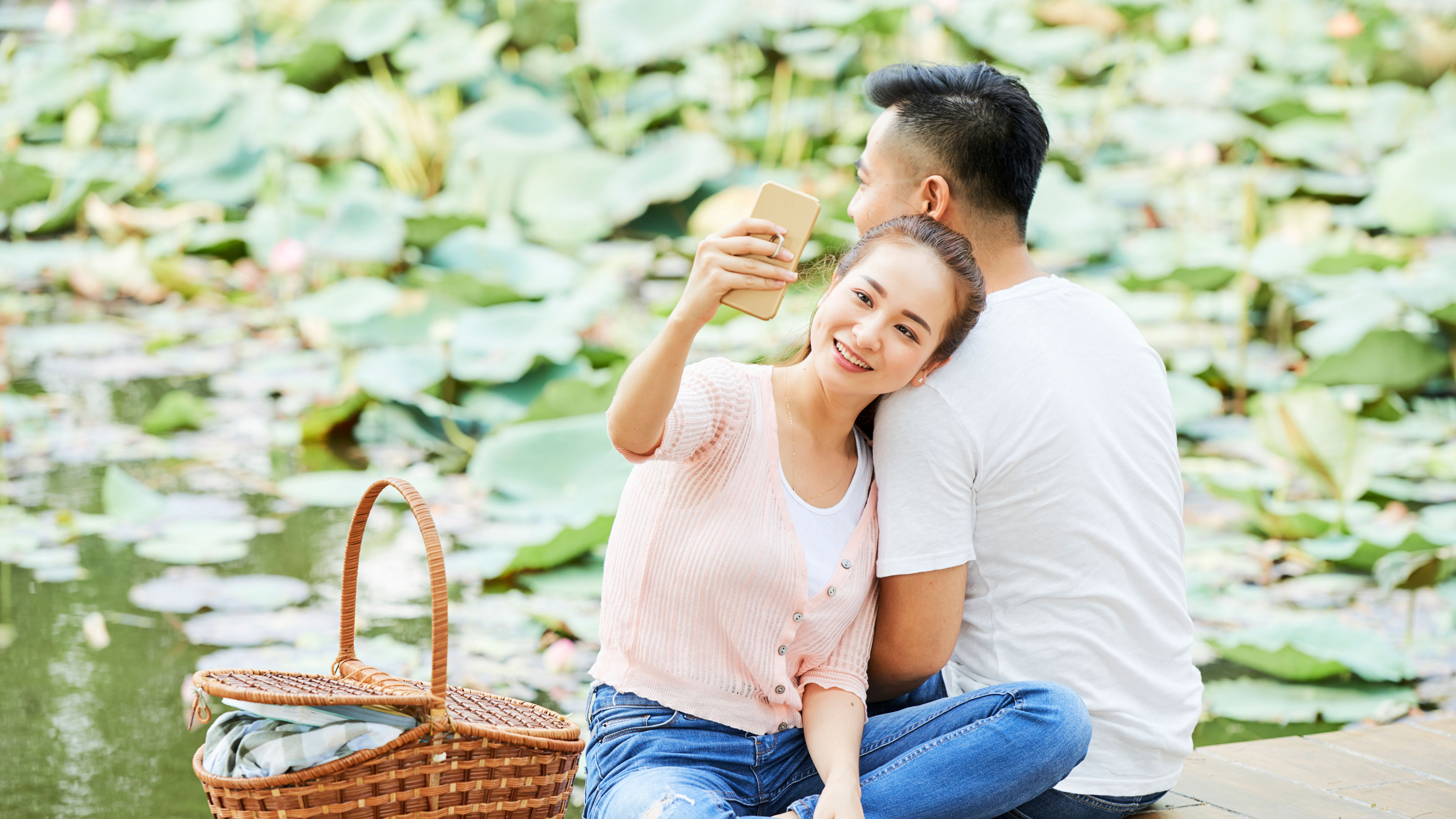 A young couple sits peacefully on a wooden deck.