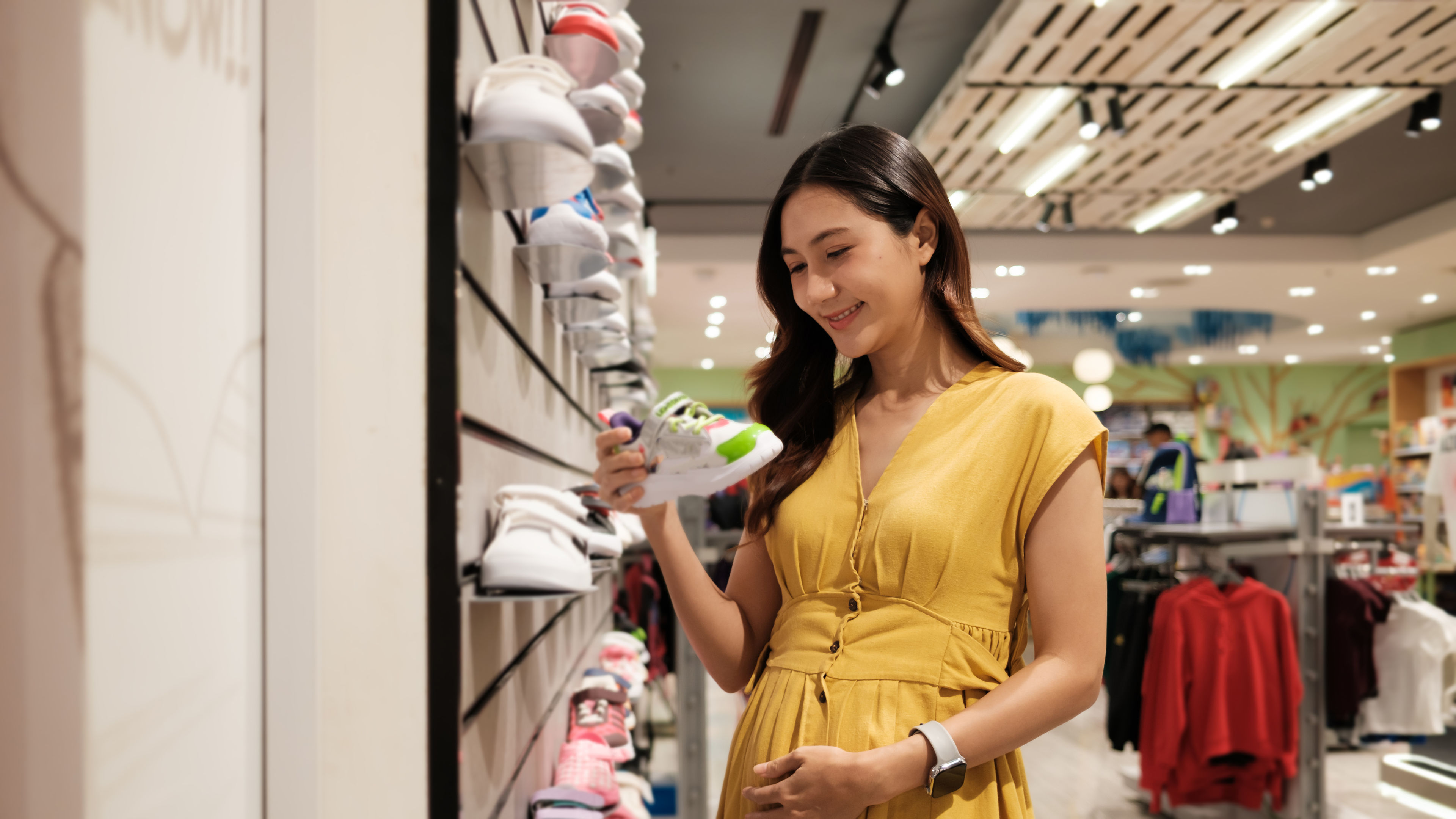 Pregnant Woman in Yellow Dress holding shoe