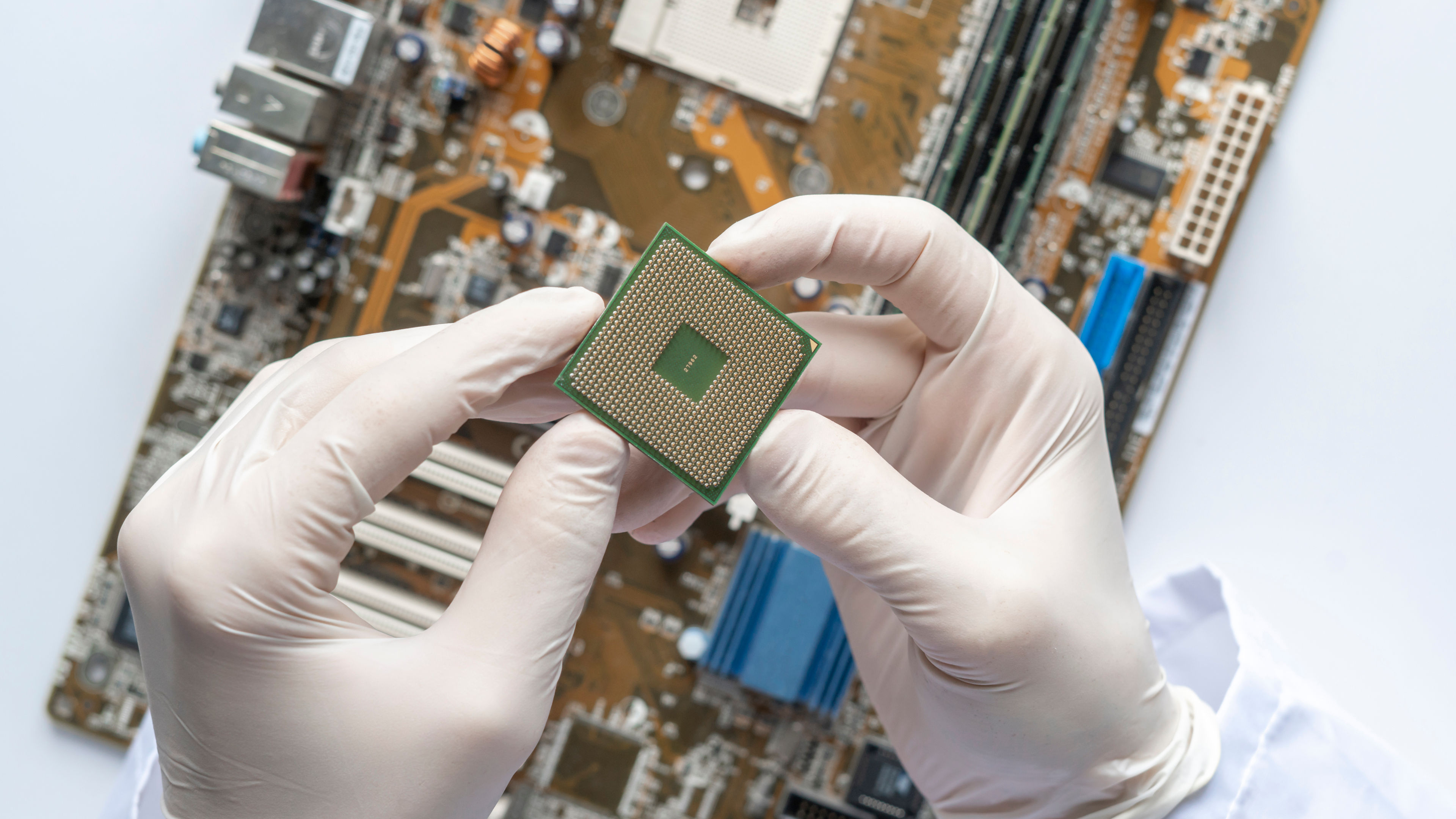 The scientist hands in gloves work with a circuit board in laboratory, close up view