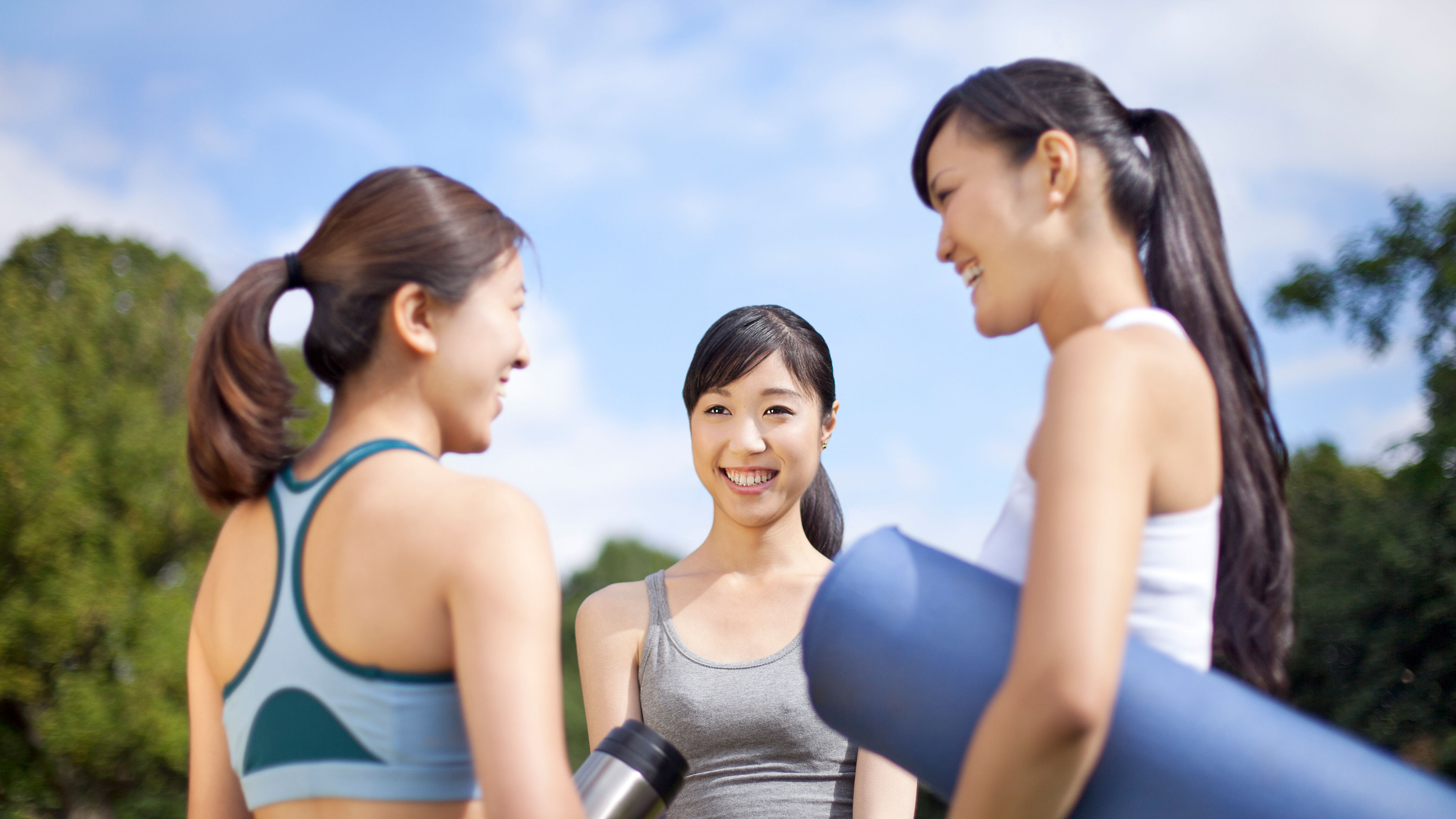 Three women preparing for yoga